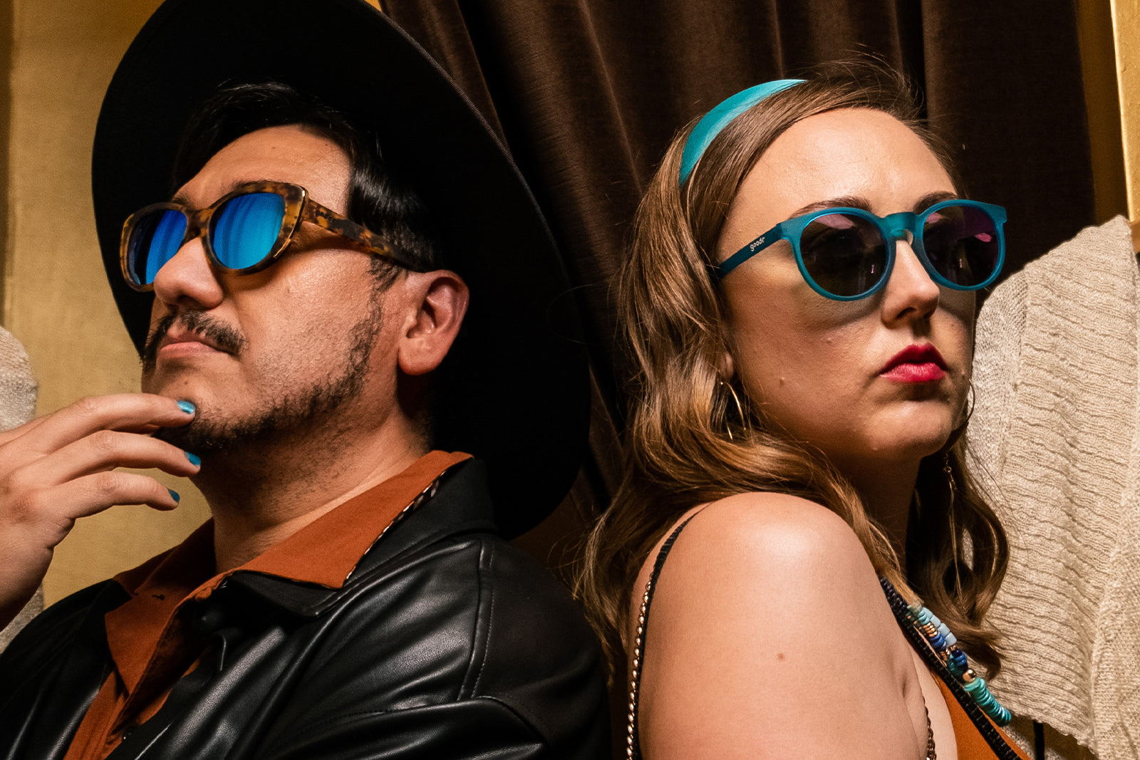 Two people standing back-to-back wearing goodr sunglasses.