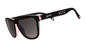 Three-quarter angle view of black and pink sunglasses with black gradient lenses and ACFC logo.
