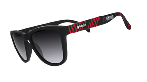 Three-quarter angle view of DC United Major League Soccer sunglasses with black and red frames and black lenses.