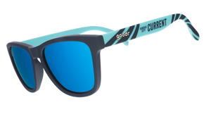 Three-quarter view of teal and storm blue sunglasses with a river current pattern, teal lenses, and the Kansas City Current logo.
