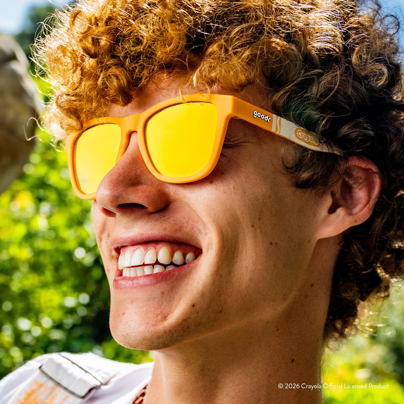 Man smiling while wearing tan sunglasses w/ white Crayola marker pattern+amber reflective lenses.