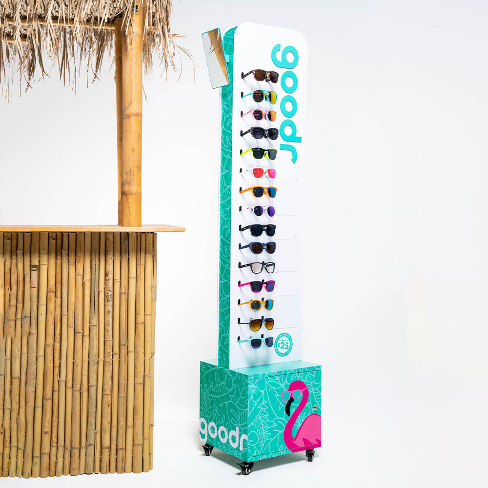 Tall, slim rack of goodr sungasses next to a bamboo table
