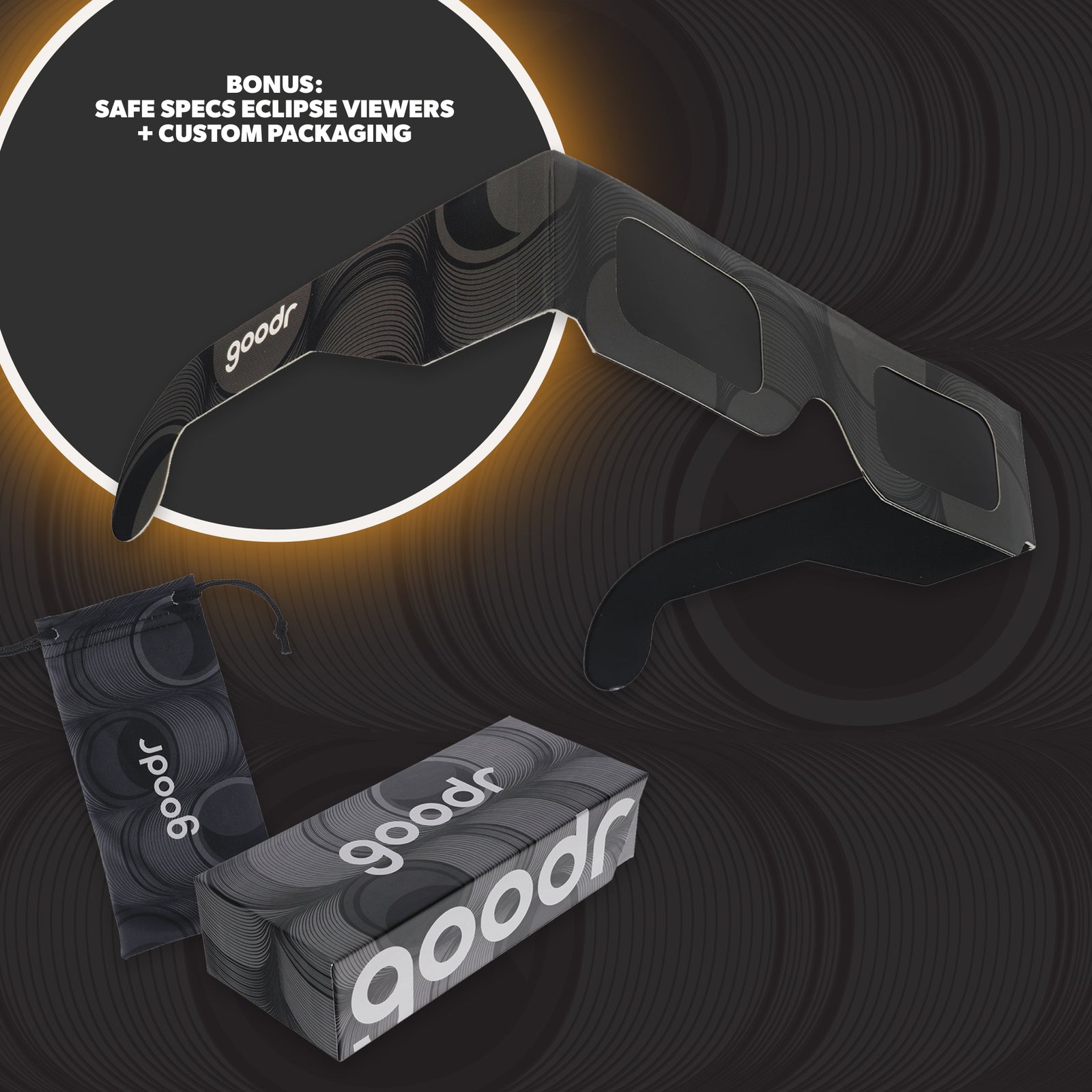 Black and gray eclipse glasses and custom packaging against a gray background.