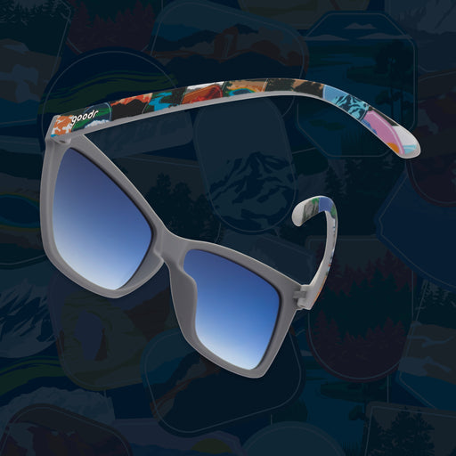 Side view of gray sunglasses with blue gradient lenses and colorful National Park Foundation temples.
