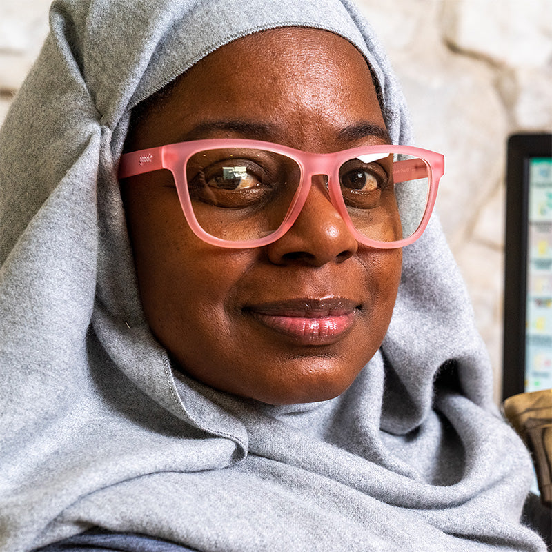 Woman wearing pink goodr glasses with clear, transparent lenses