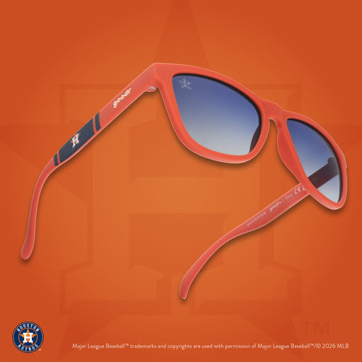 Three-quarter angle view of a pair of orange and navy sunglasses against an orange background featuring the Lone Star H logo.