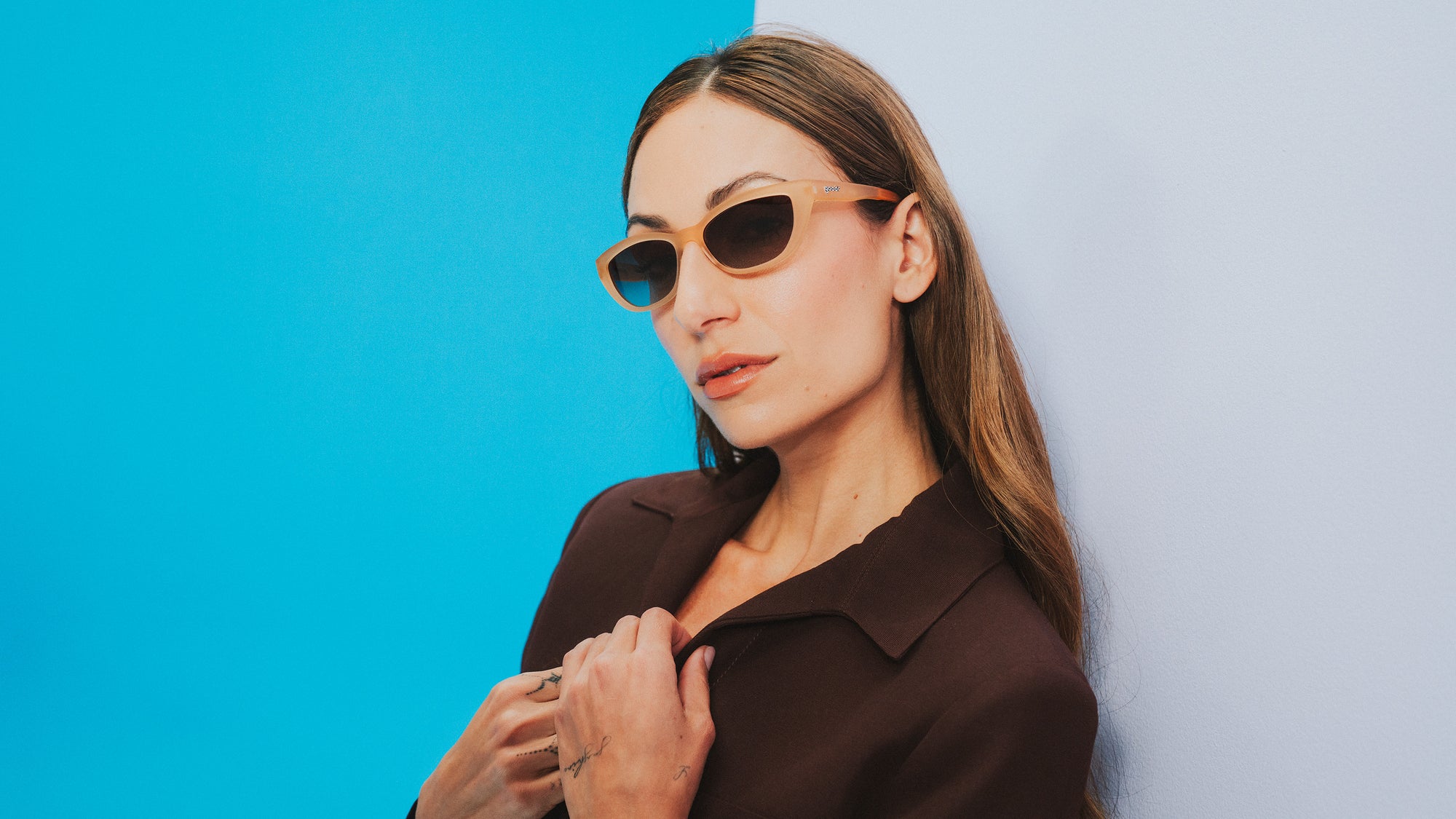 Person wearing pastel goodr sunglasses against a blue background.