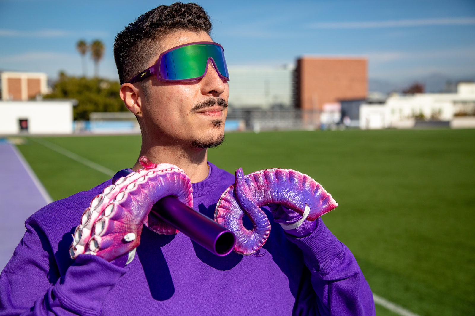 Man wearing sports sunglasses with purple frames and green/blue reflective lenses