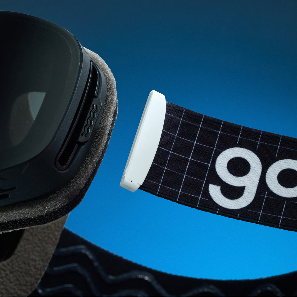Close-up of black grid-pattern goodr goggle strap attached to black ski goggles.