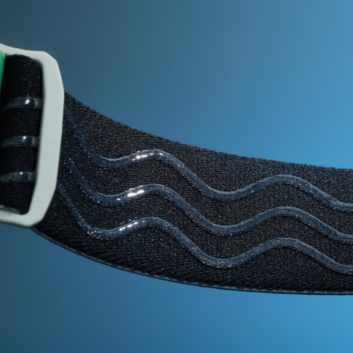 Close-up of black elastic goggle strap with raised wavy silicone grip lines.