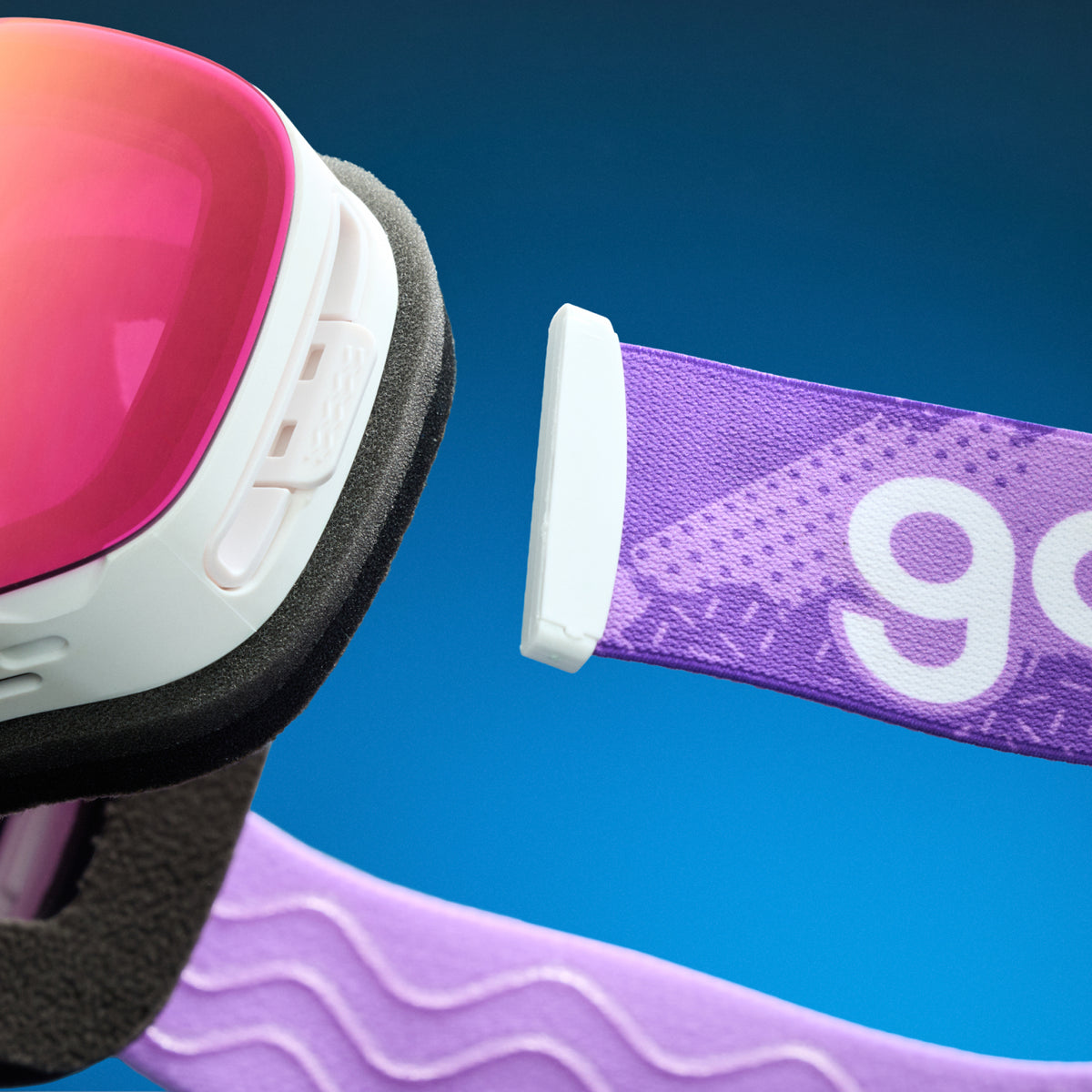 Close-up of purple red mirrored snow goggles with a detachable purple goodr strap.