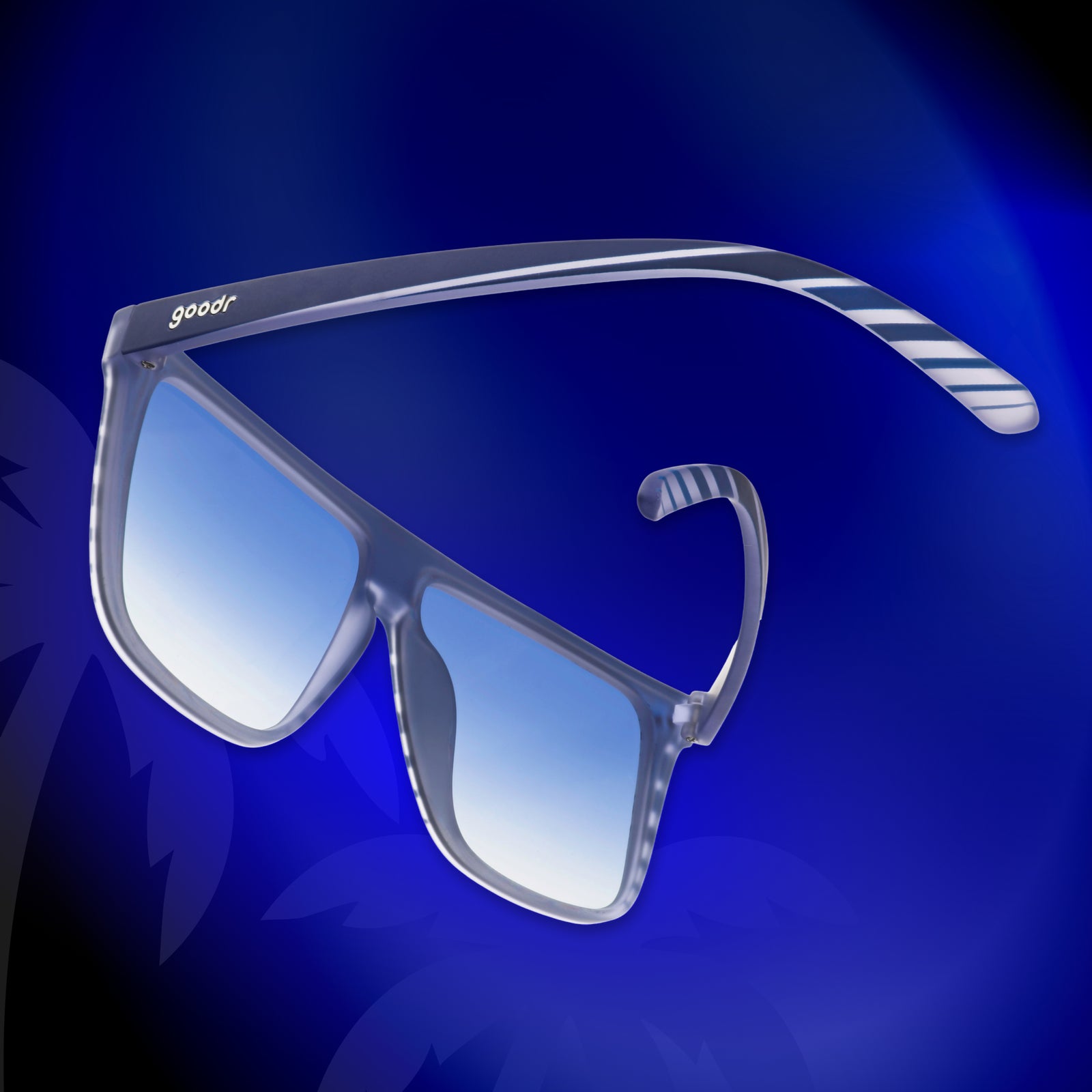 A pair of retro flat-top Fly Gs is photographed from behind, floating on a deep blue palm tree background.