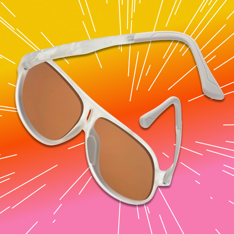 Angled view of aviator sunglasses with a translucent white frame and brown non-reflective lenses.