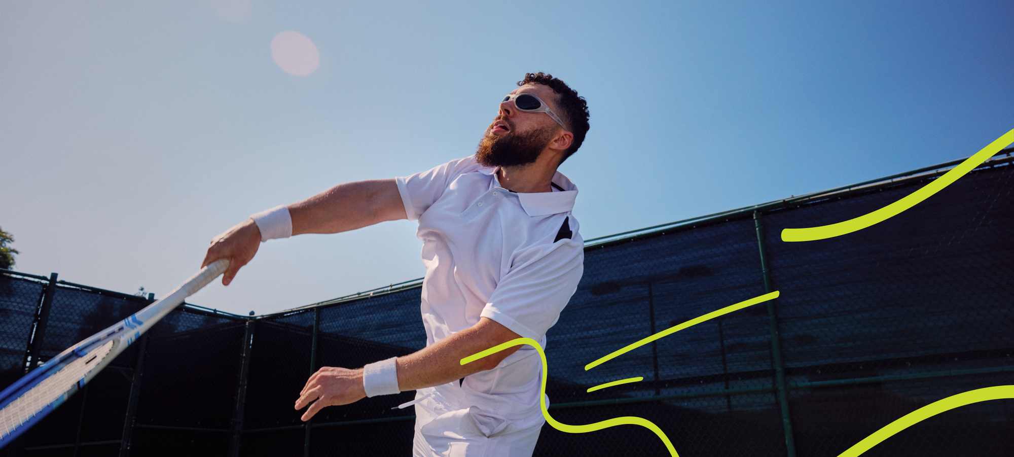 A man outside wearing a white polo shirt and swatting a tennis racket, wearing bug-like sunglasses with translucent frames and dark lenses.