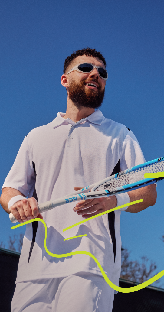 A man wearing a white polo shirt and holding a tennis racket, wearing bug-like sunglasses with translucent frames and dark lenses.